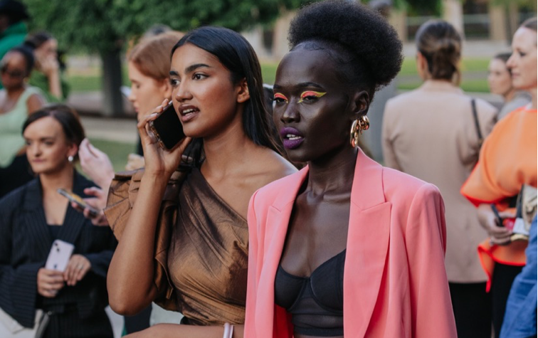 Two people dressed up with one talking on a phone.